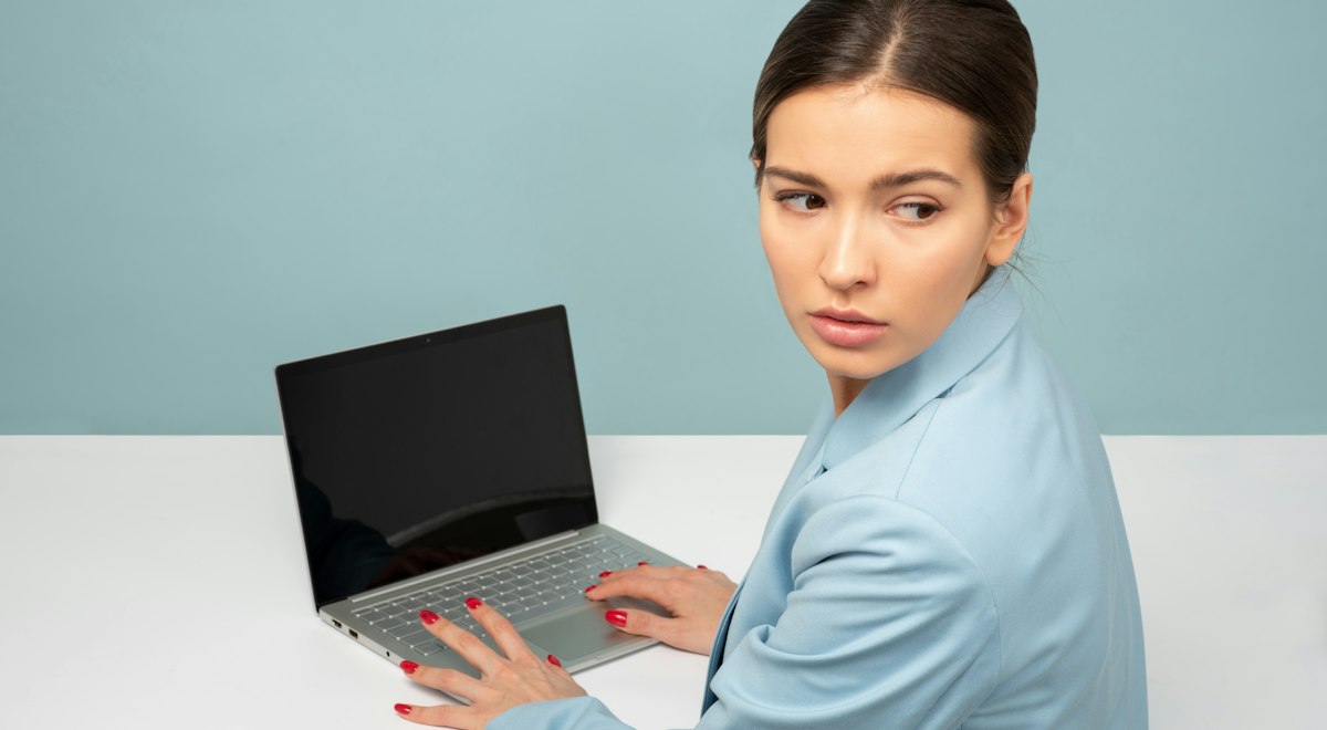 Woman using a laptop at a desk, illustrating digital eye strain from screen use