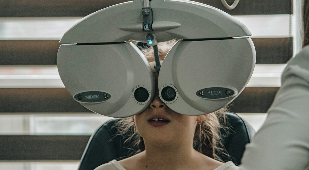 Patient looking into a phoropter during an eye examination